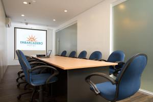 a conference room with a wooden table and blue chairs at Ellis Ecotel in Legazpi