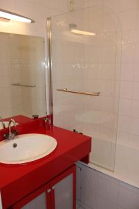 La salle de bains est pourvue d'un lavabo rouge et d'une douche. dans l'établissement Schuss Appartements VTI, à Val Thorens