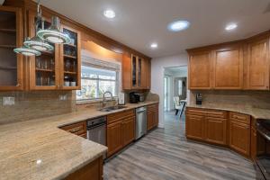 eine große Küche mit Holzschränken und einem Waschbecken in der Unterkunft Cozy Riverfront Home with Pool in Indianola + 42 Fotos