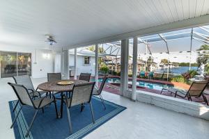 ein Esszimmer mit einem Tisch, Stühlen und einem Pool in der Unterkunft Cozy Riverfront Home with Pool in Indianola