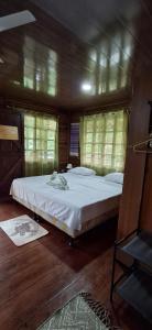 a bedroom with a large bed with white sheets at Cabañas Retiro Del Rio in Guayabal