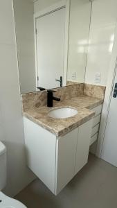 een badkamer met een wastafel en een toilet bij Apartamento Res Ilha Bella in Passo De Torres