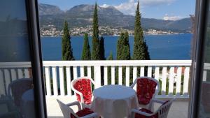 einen Tisch und Stühle mit Blick auf das Wasser in der Unterkunft Villa Boka Sunrise Apartments in Herceg-Novi