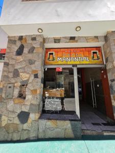 a building with a sign on the front of it at Hotel Manantial in Churín