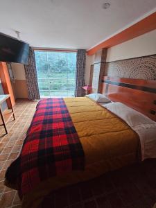 a bedroom with a bed and a large window at Hotel Manantial in Churín