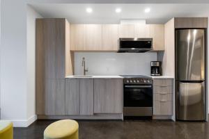 Una cocina con refrigerador de acero inoxidable y microondas. en Le William, en Montreal