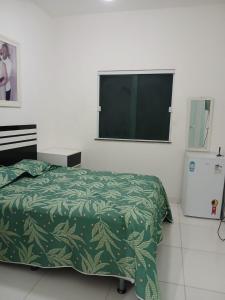 伊塔帕里卡岛维拉克鲁兹Casa de praia em Barra do Gil的一间卧室，里面有一张床和一台平板电视