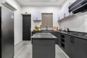 cocina grande con electrodomésticos en blanco y negro en Aduni's Place, en Ikeja