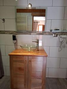 ein Badezimmer mit einem Glaswaschbecken auf einer Holztheke in der Unterkunft HOTEL & HOSTAL CHIL'IN, Las Trancas in Las Trancas