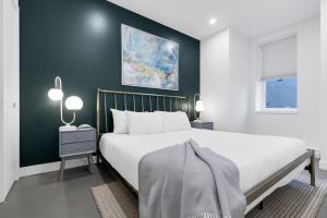 Un dormitorio con una cama blanca y una pared verde. en Le William, en Montreal