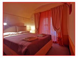 a bedroom with a large bed with red curtains at Casa GALILEO- Antiche Dimore Pisane in Pisa