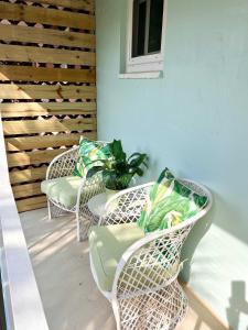 a patio with three chairs and a table with a plant at Coastal Countdown Relaxed Townhome Near Beach and Rockets in Cape Canaveral