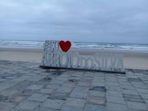 una panchina con un cuore sopra sulla spiaggia di Casa na praia a Arroio do Silva
