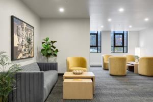 Una sala de estar con sillas, un sofá y una mesa. en Le William, en Montreal