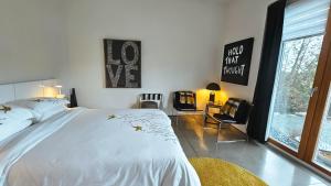 una camera da letto con un grande letto bianco e una finestra di The Cube Cow Bay Suite a Cowichan Bay