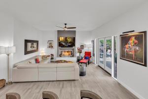 un soggiorno con un divano bianco e un camino di Modern, Upgraded, Resort-Style a Chandler