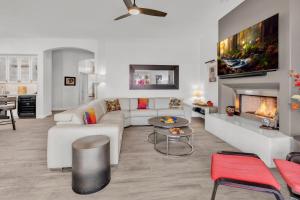 un soggiorno con un divano bianco e un camino di Modern, Upgraded, Resort-Style a Chandler