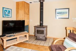a living room with a television and a wood stove at Calypso in Lincoln City