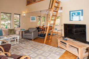 a living room with a television and a ladder at Calypso in Lincoln City