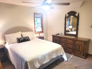 a bedroom with a bed and a dresser and a mirror at New! Crystal Pines - Lovely Crystal Mountain Cabin in Thompsonville