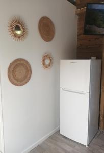 La pause verte bungalow في ساينت آن: ثلاجة بيضاء في غرفة معلقة عليها قبعات +16 صورة