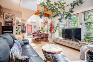 Una sala de estar con un sofá y un televisor en Sapporoの実家 B&B Yoshida, en Sapporo