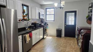 a kitchen with white cabinets and a sink and a refrigerator at Vintage Home Vibe in Jersey City