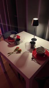 EyguièresUne Pause Douceur - Suite All in Wood的桌子上摆着碗碟和一盏灯。