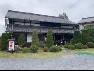 a building with a bunch of bushes in front of it at 天狗の茶屋旅館 in Miyota