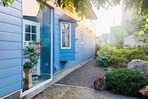 Una casa azul con una puerta azul al costado. en Sapporoの実家 B&B Yoshida, en Sapporo