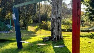 een groep schommels in een park naast een boom bij Casas de Campo com Piscina, Pesca - Mata Atlântica in Juquitiba