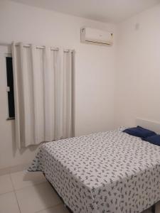 a bedroom with a bed with a black and white comforter at Casa de praia em Barra do Gil in Vera Cruz de Itaparica +36 photos