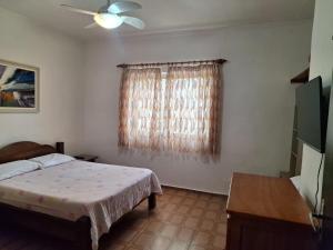a bedroom with a bed and a window at Casa Térrea Espaçosa Centro , Bertioga-Pertinho da Praia in Bertioga