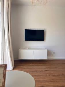 a living room with a tv on a white wall at Anahata Homes in Antigua