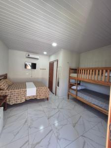 een slaapkamer met een bed en een stapelbed. bij Chalés Brisa do Mar in Amontada