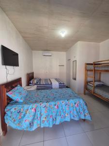 een slaapkamer met een bed en een flatscreen-tv bij Chalés Brisa do Mar in Amontada +7 foto's