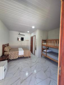 een slaapkamer met een bed en een stapelbed. bij Chalés Brisa do Mar in Amontada