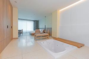 a large white tub in a room with a couch at Iconik Hotel in Medellín +66 photos