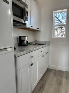 a kitchen with white cabinets and a sink and a window at Holiday Isles Resort in St. Pete Beach