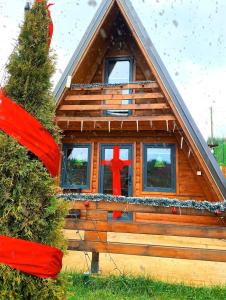 a log cabin with a christmas tree in front of it at Villa Konezal in Ferizaj
