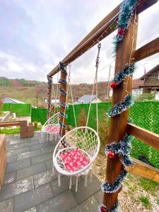 a porch with two chairs and a swing at Villa Konezal in Ferizaj
