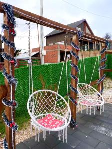 two chairs on a swing in a yard at Villa Konezal in Ferizaj