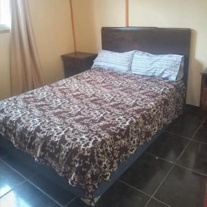 a bedroom with a bed with a brown blanket at Mateo y Stella 3 in Bialet Massé