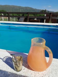 a vase and a cup on a table next to a pool at Mateo y Stella 3 in Bialet Massé +6 photos