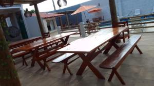 サン・フランシスコ・デ・イタバポアナにあるPousada Casa da Praia SFIの木製のテーブルとベンチが並ぶパティオ +2枚の写真