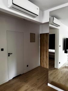an empty room with a white wall and a door at Apartament Morzlive in Ustronie Morskie