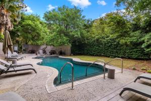 a swimming pool in a yard with chairs and trees at 5556 Cypress Point in Kiawah Island