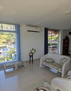 un soggiorno con divano, tavolo e finestre di Cabañas Annapurna - jacuzzi privado con espectacular vista a Taganga Altre 55 foto