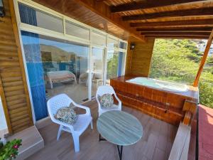 un portico con tavolo, sedie e una vasca di Cabañas Annapurna - jacuzzi privado con espectacular vista a Taganga