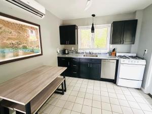 a kitchen with black cabinets and a wooden table at Featherstone Downstairs Apartment, Cayman Brac in Cayman Brac